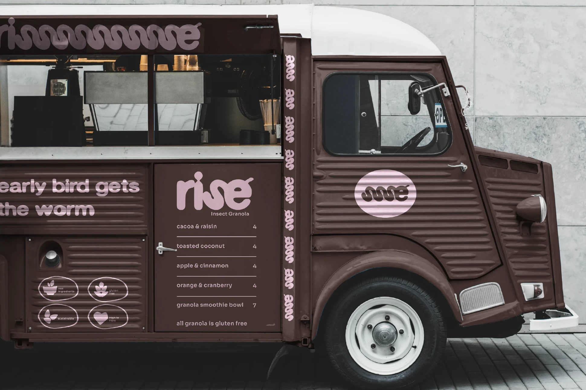A brown vintage food van branded with the rise logo, menu and patterns